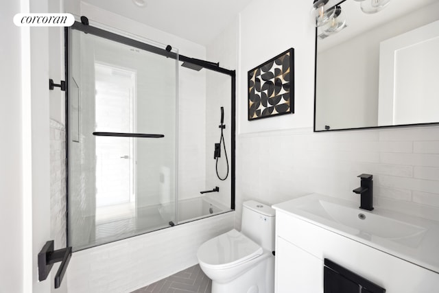 full bathroom featuring toilet, vanity, tile walls, tasteful backsplash, and shower / bath combination with glass door