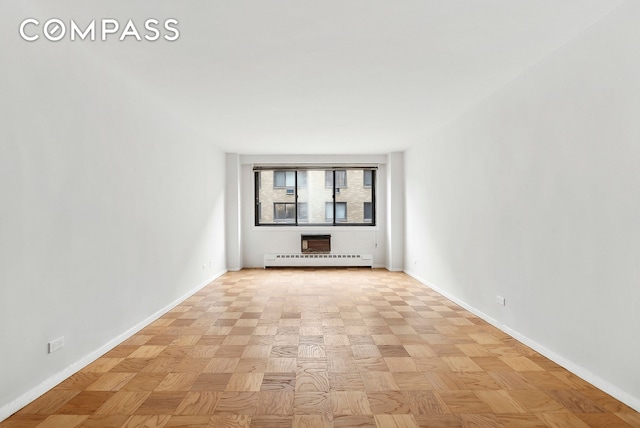 empty room featuring baseboards and baseboard heating