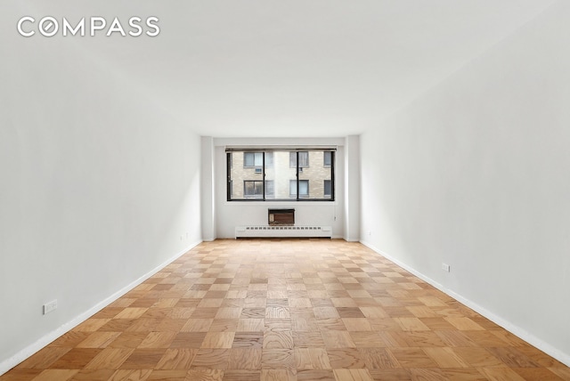 empty room with baseboards and a baseboard radiator
