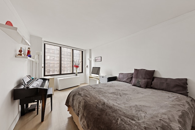 bedroom featuring crown molding and wood finished floors