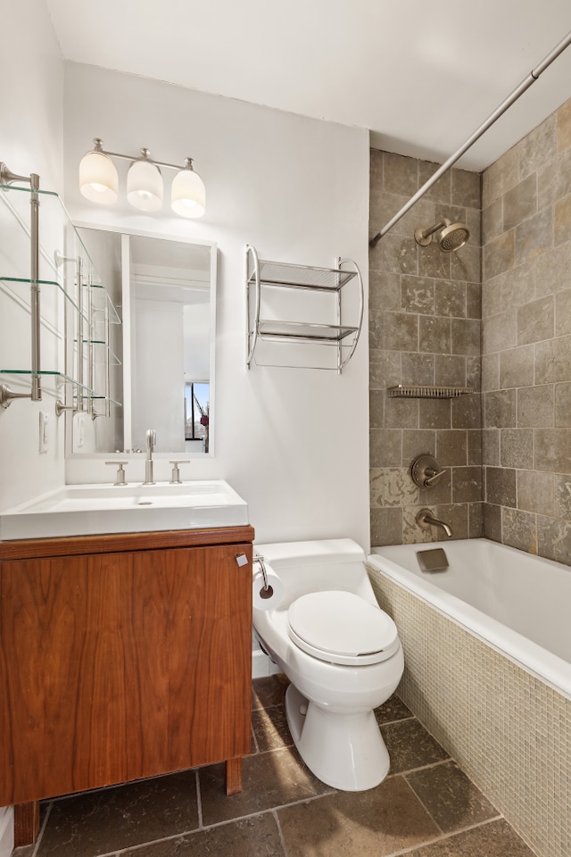 full bath featuring toilet, tiled shower / bath combo, and vanity