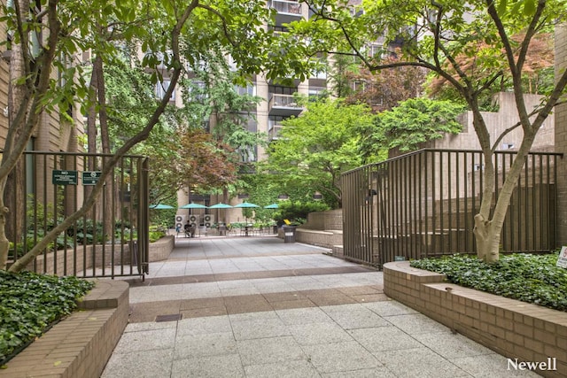 view of home's community featuring a gate, a patio area, and fence