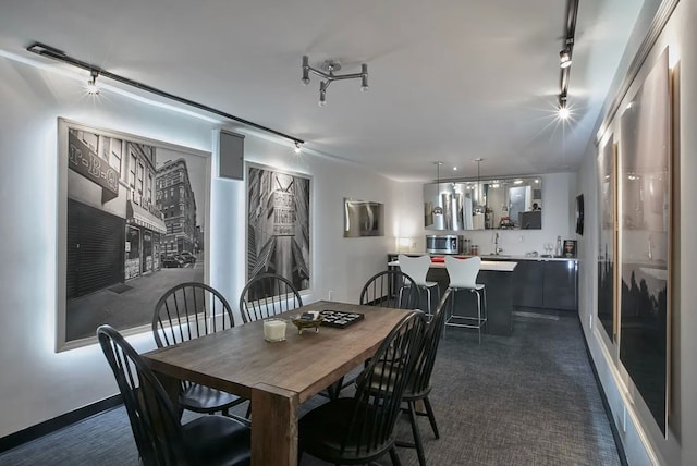 dining room with track lighting and dark colored carpet