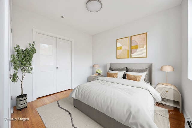 305 W 150th St Unit 505, New York City, NY 10039 - bedroom with wood finished floors, a baseboard radiator, and a closet