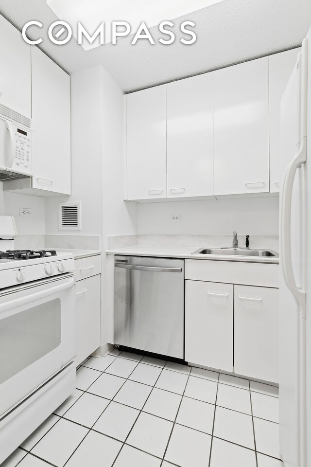 kitchen with sink, white cabinets, and white appliances