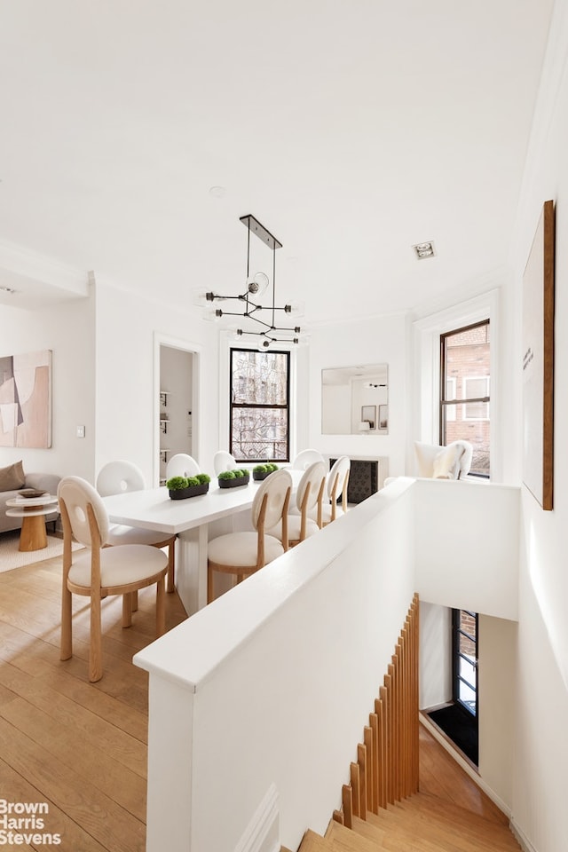 staircase with a notable chandelier and wood finished floors