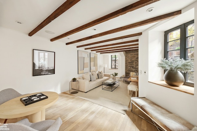 living area with beamed ceiling and wood finished floors