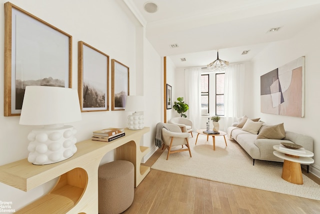 living area featuring visible vents and wood finished floors