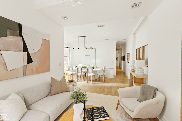 living area with wood finished floors, visible vents, and baseboards