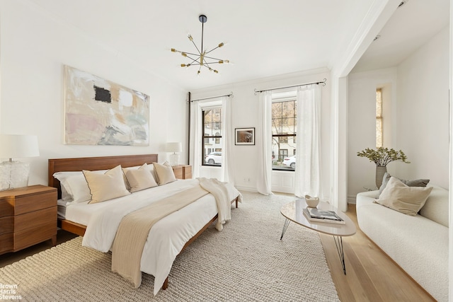 bedroom with crown molding, baseboards, a notable chandelier, and wood finished floors