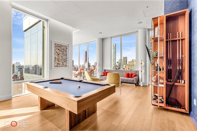 game room with floor to ceiling windows, billiards, and light hardwood / wood-style flooring