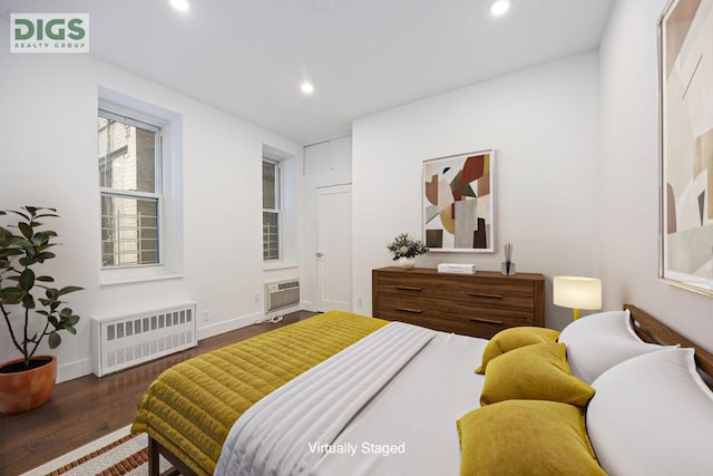 bedroom featuring radiator, dark hardwood / wood-style floors, and a wall mounted air conditioner