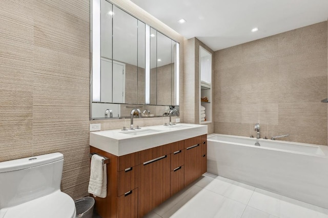 bathroom featuring toilet, vanity, tile walls, tile patterned floors, and a tub