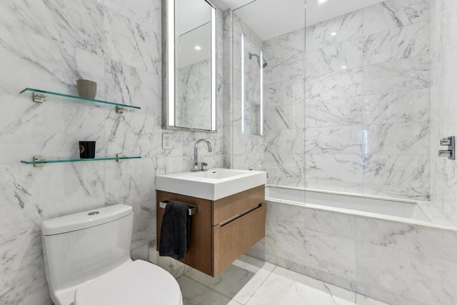 full bathroom with tile walls, toilet, vanity, and tiled shower / bath