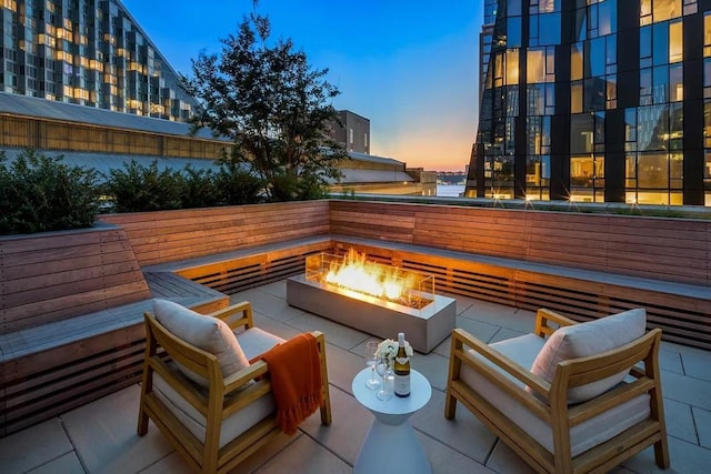 patio terrace at dusk featuring an outdoor living space with a fire pit