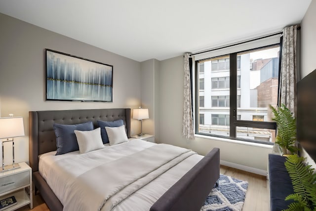 bedroom featuring light wood-style flooring and baseboards