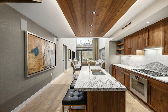 90 Furman St Unit N210, New York City, NY 11201 - kitchen with stainless steel appliances, wood ceiling, a breakfast bar, light wood-type flooring, and open shelves