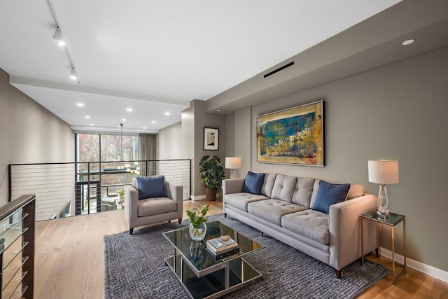 living area featuring recessed lighting, rail lighting, baseboards, and wood finished floors