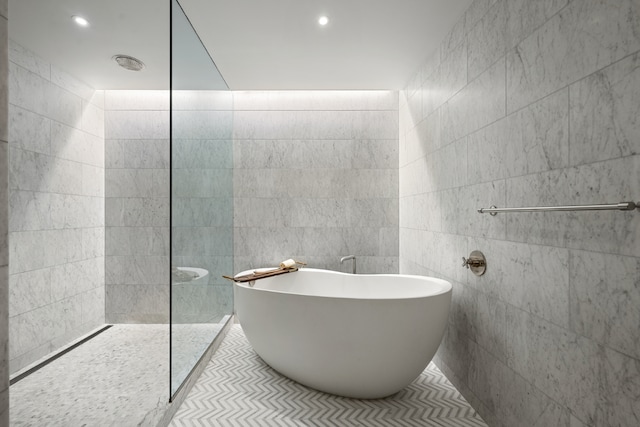 bathroom featuring tile walls, recessed lighting, a soaking tub, tile patterned floors, and walk in shower