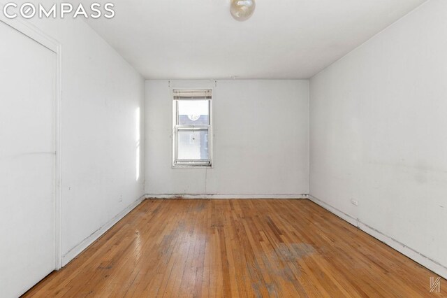 spare room with hardwood / wood-style floors and radiator heating unit