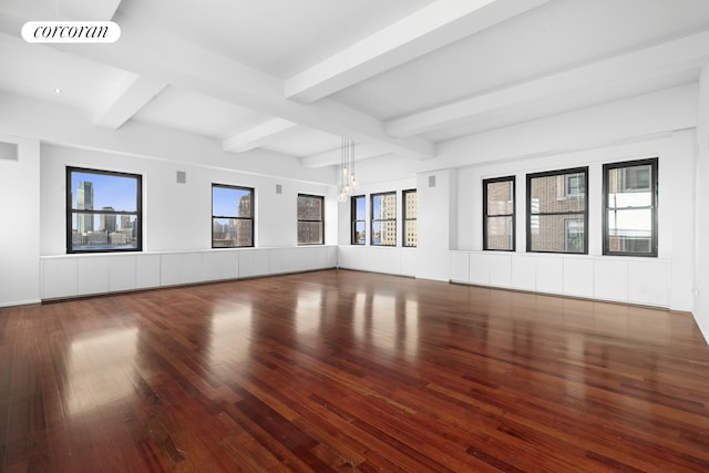 empty room with visible vents, beam ceiling, an inviting chandelier, and hardwood / wood-style floors