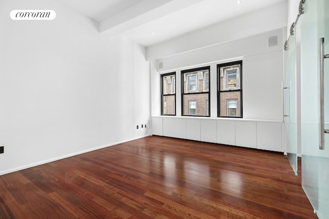 empty room with visible vents, wood finished floors, and baseboards