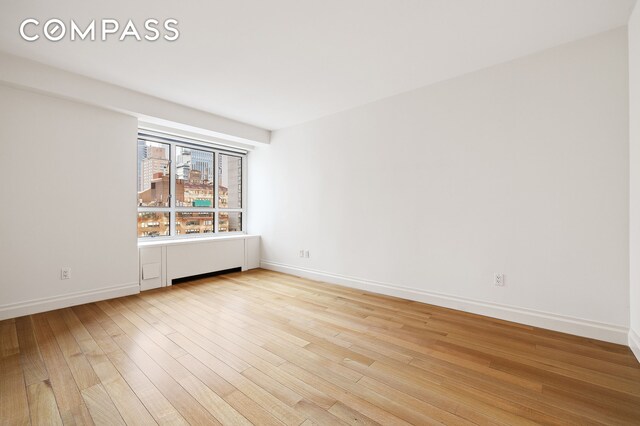 200 E 66th St Unit D1203, New York City, NY 10065 - unfurnished room with baseboards and light wood-type flooring