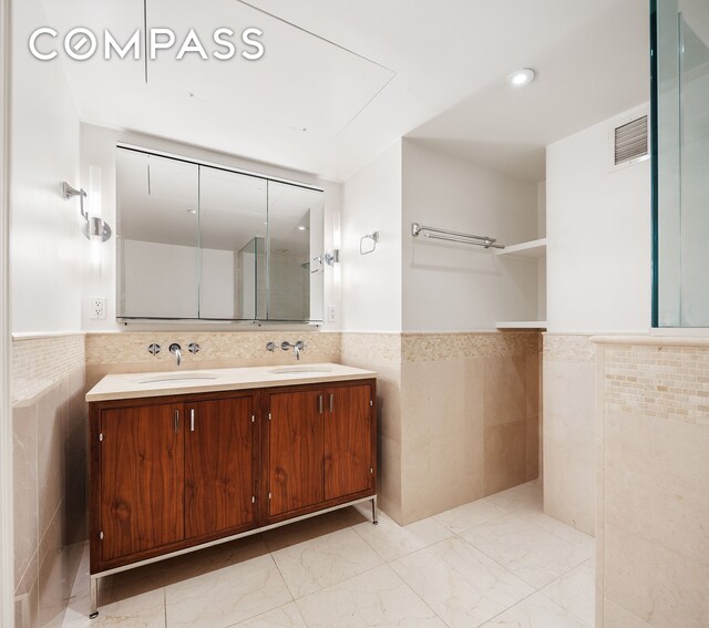 200 E 66th St Unit D1203, New York City, NY 10065 - bathroom with tile walls, visible vents, marble finish floor, and wainscoting