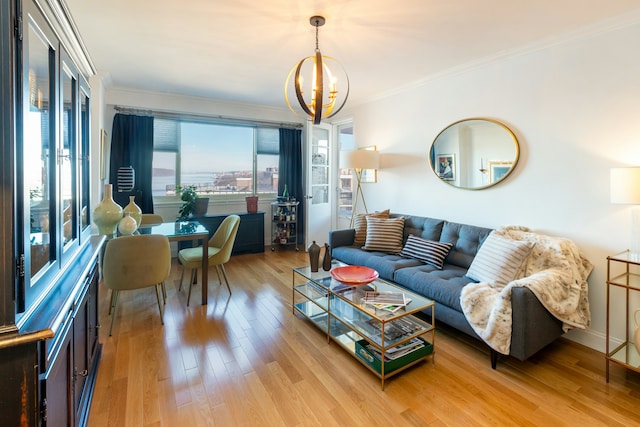 living area with ornamental molding, a notable chandelier, and wood finished floors