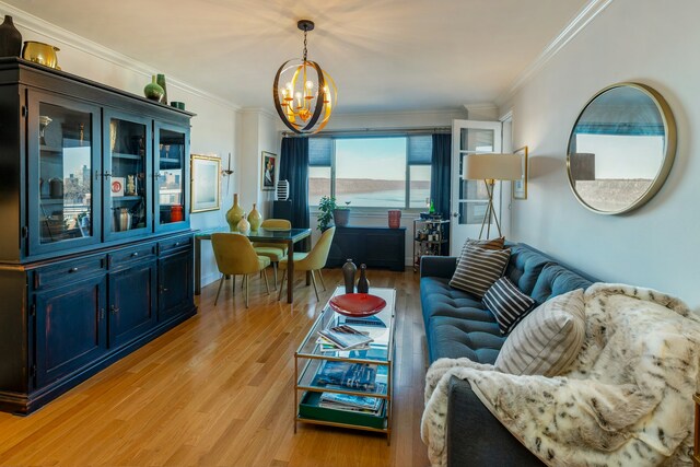 living area featuring ornamental molding, a chandelier, and light wood finished floors