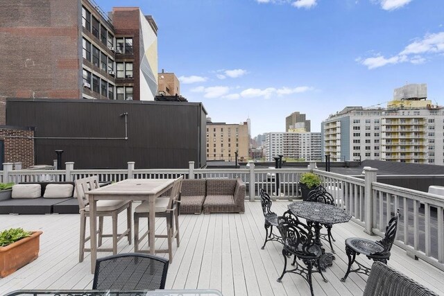 wooden terrace featuring a view of city and outdoor lounge area