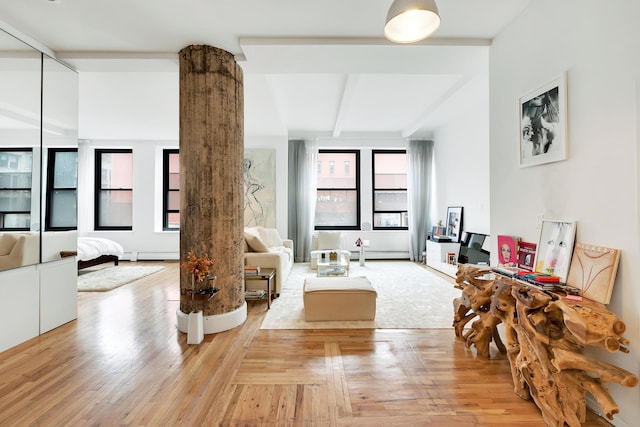 250 Mercer St Unit B603, New York City, NY 10012 - living room with plenty of natural light, beamed ceiling, light wood-type flooring, and a baseboard radiator