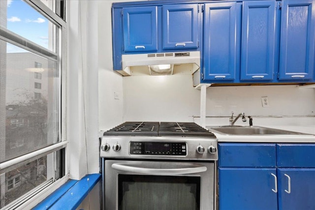 kitchen featuring blue cabinets, gas range, and sink