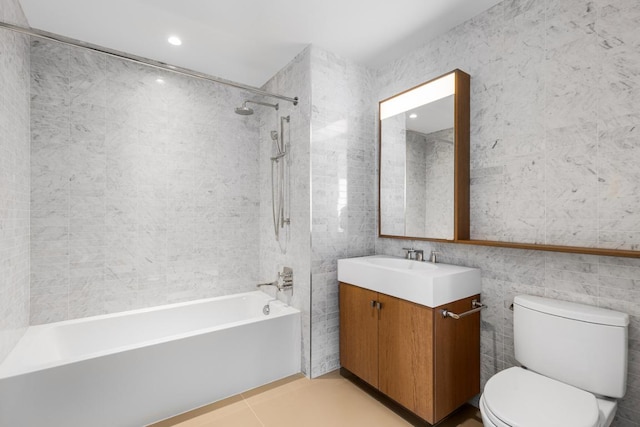 full bathroom featuring toilet, vanity, tile walls, and shower / washtub combination