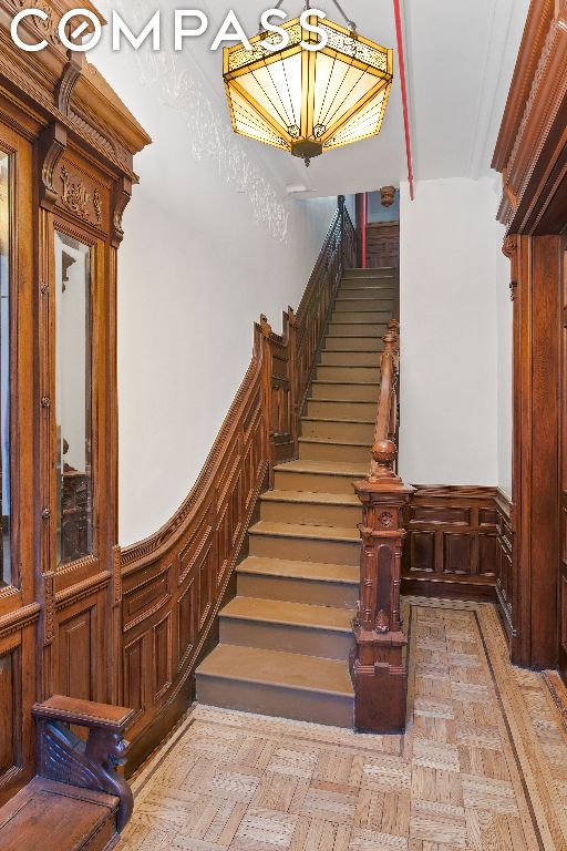 staircase featuring ornamental molding and parquet flooring