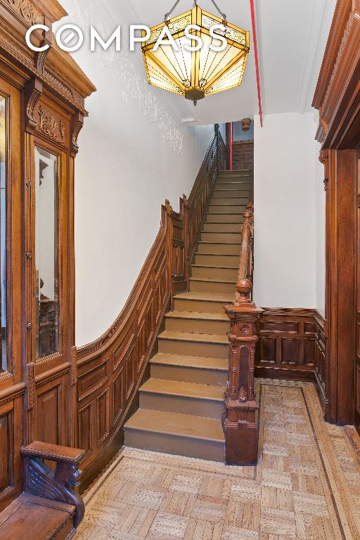 staircase featuring a wainscoted wall