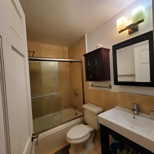 full bath featuring combined bath / shower with glass door, toilet, and vanity