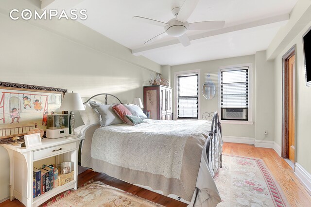 bedroom featuring ceiling fan, light hardwood / wood-style floors, and cooling unit