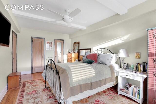 bedroom with ceiling fan, beamed ceiling, and light hardwood / wood-style flooring