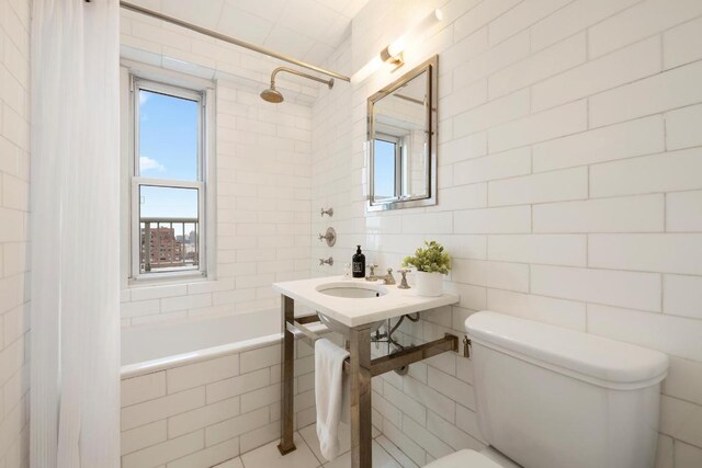 full bathroom featuring sink, a wealth of natural light, toilet, and shower / bathtub combination with curtain