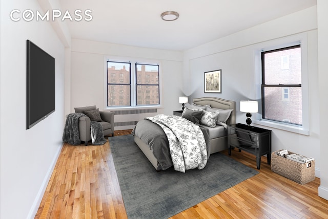 99-21 67th Rd Unit 7A, New York City, NY 11375 - bedroom with radiator heating unit, light wood-style flooring, and baseboards