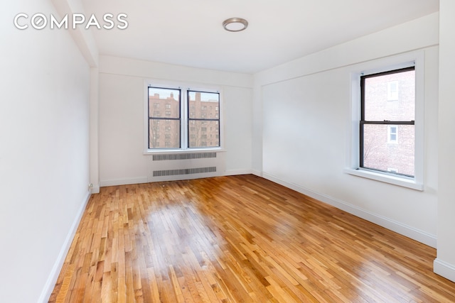 99-21 67th Rd Unit 7A, New York City, NY 11375 - empty room featuring radiator heating unit, light wood-style flooring, and baseboards