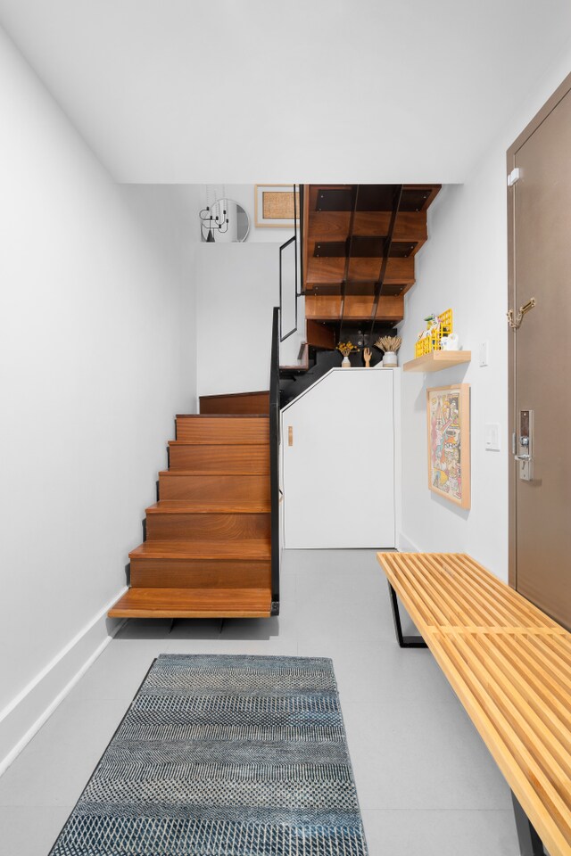 staircase featuring tile patterned flooring and baseboards