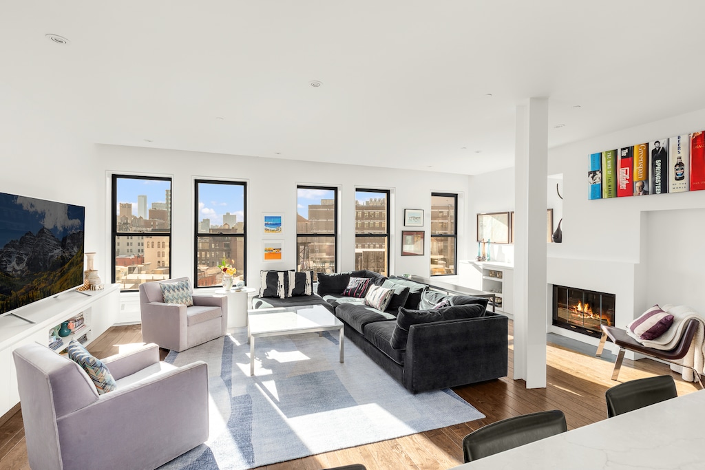 living area with a glass covered fireplace and wood finished floors