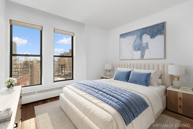 bedroom featuring baseboard heating and light hardwood / wood-style floors