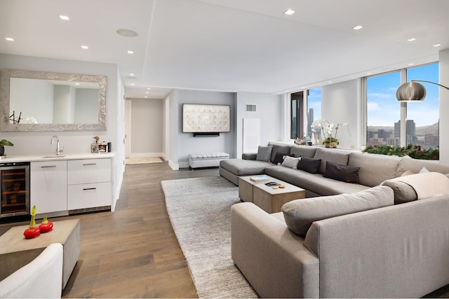 living area featuring beverage cooler, visible vents, dark wood-type flooring, indoor wet bar, and recessed lighting