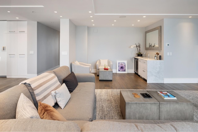 living area with baseboards, wood finished floors, and recessed lighting