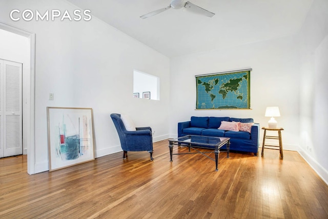 sitting room with a ceiling fan, baseboards, and wood finished floors