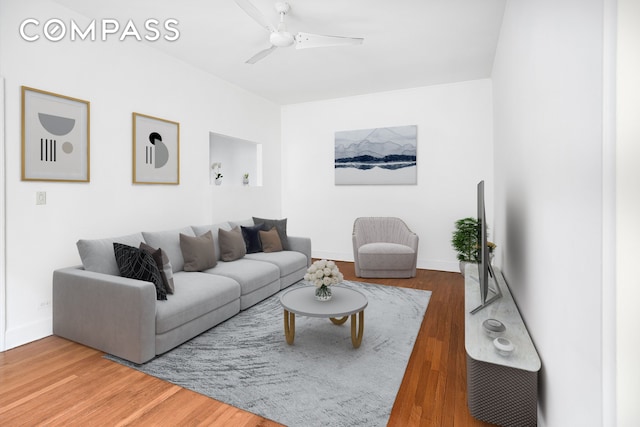 living room with wood finished floors, ceiling fan, and baseboards