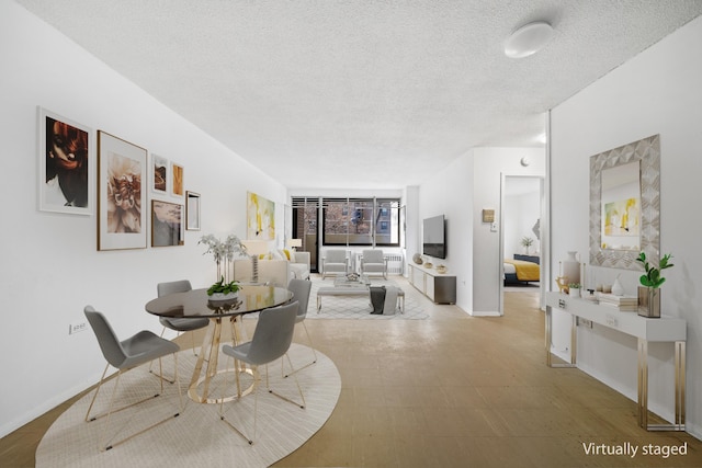 dining area with a textured ceiling and baseboards